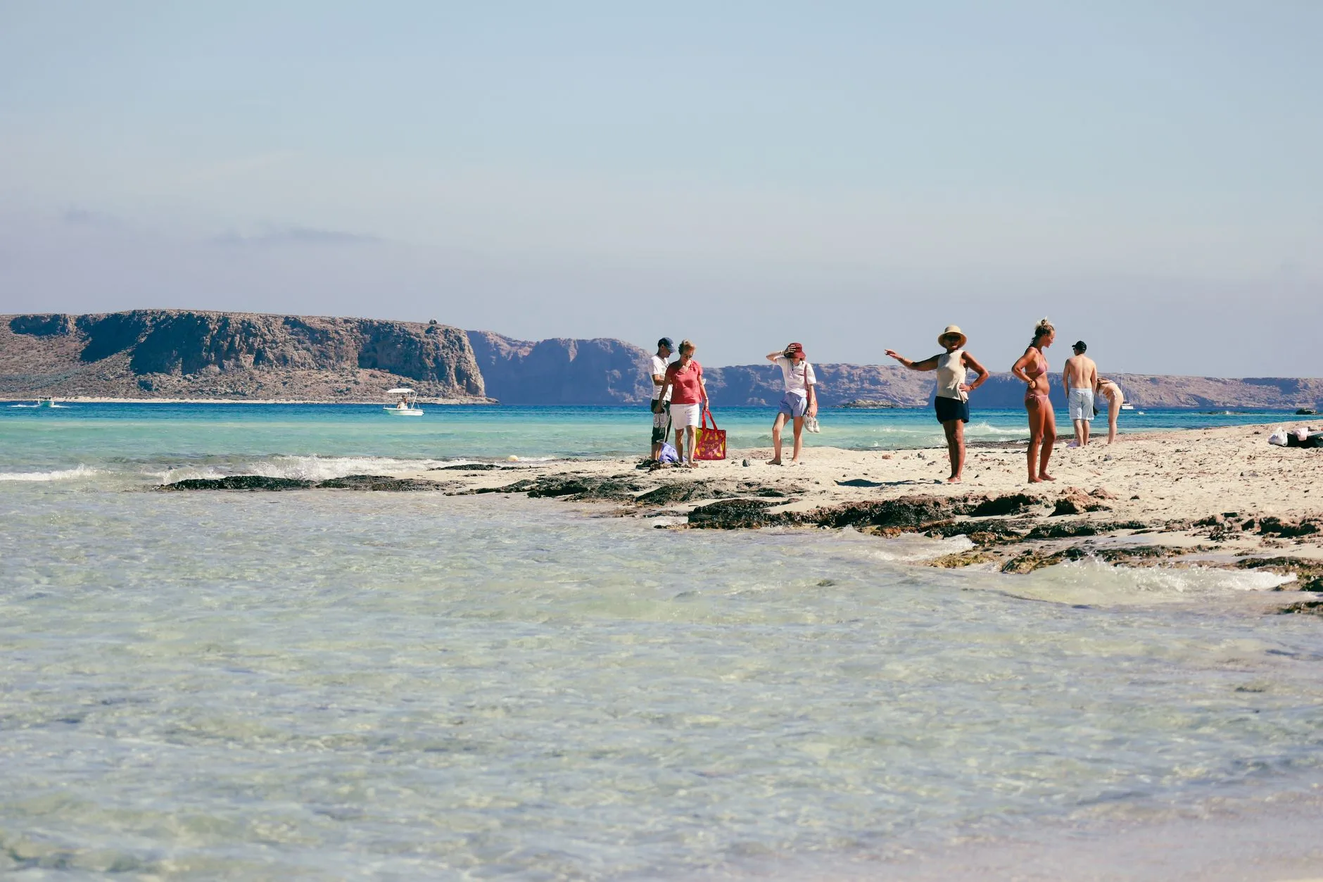 Famille sur une plage de sable aux eaux turquoise peu profondes en Crète
