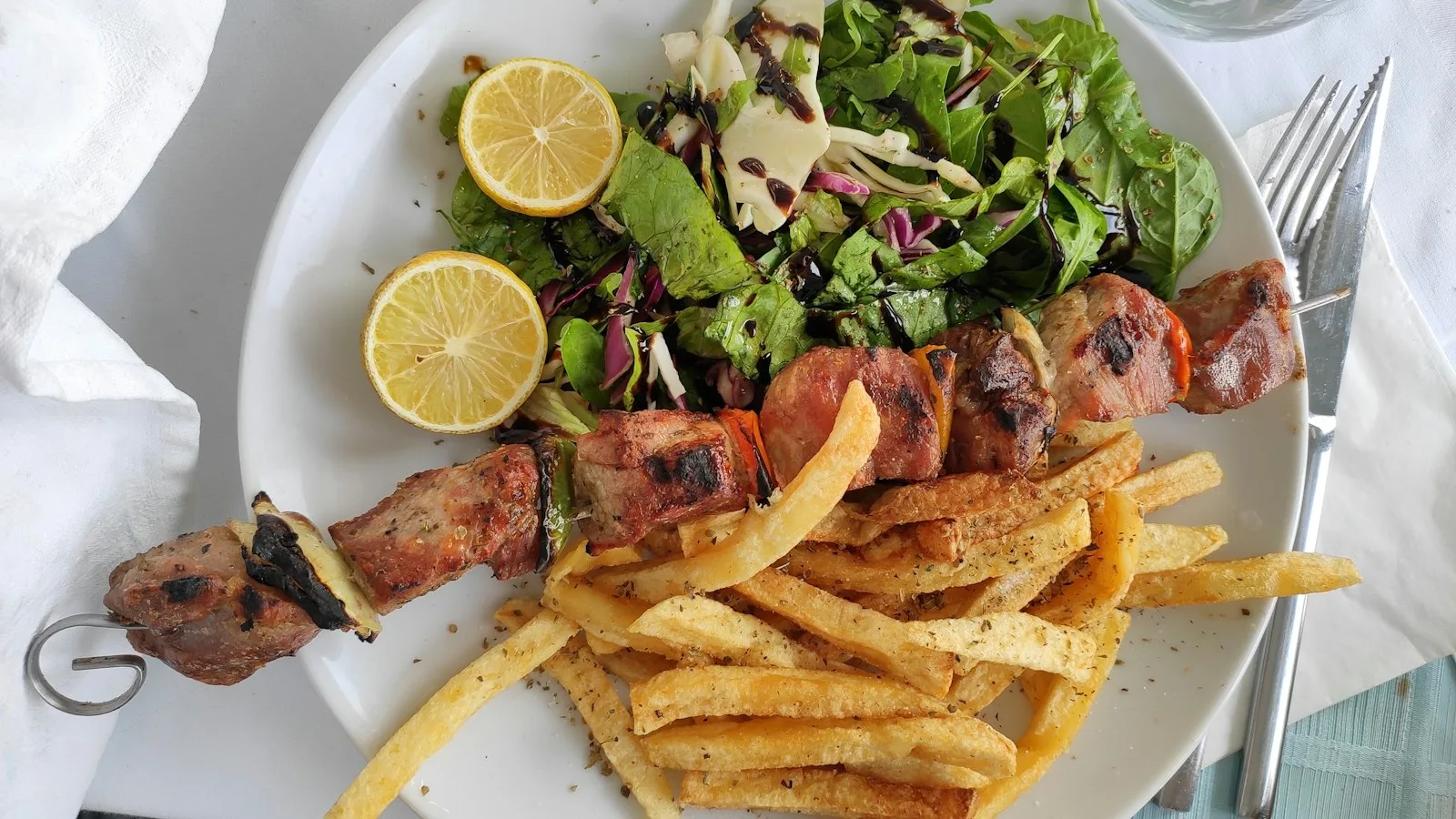 Addition et petite monnaie posées sur la table d'une taverne crétoise en terrasse